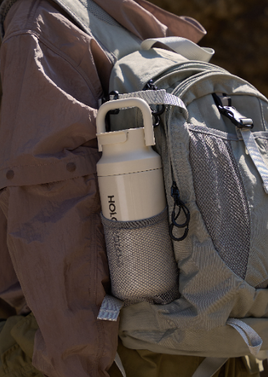 HOLOHOLO outdoor insulated water bottle with a handle, designed for easy carrying and keeping beverages cold or hot. Perfect for hiking or outdoor adventures, conveniently attached to a backpack.